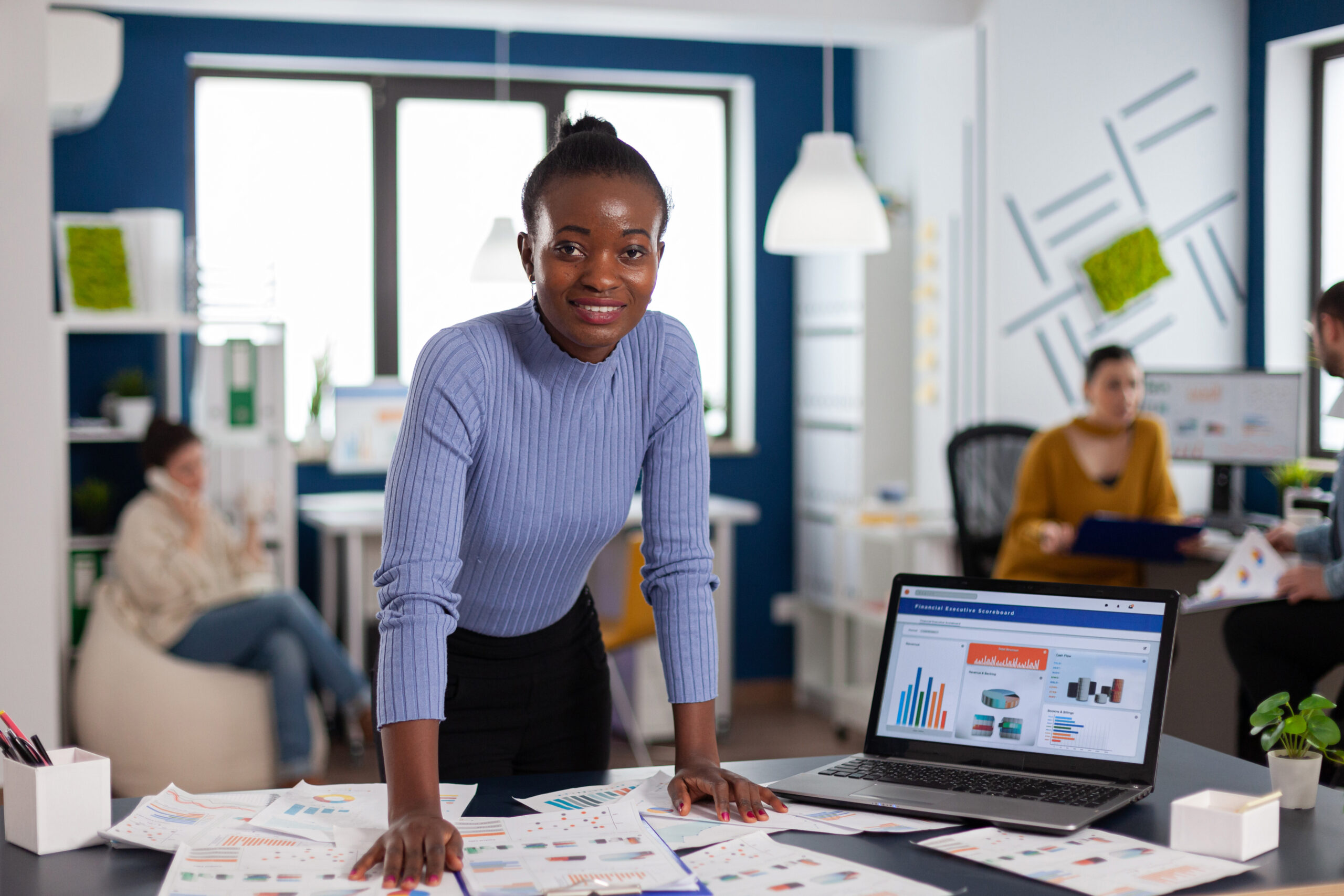 dark skinned woman and colleagues in corporate start up office